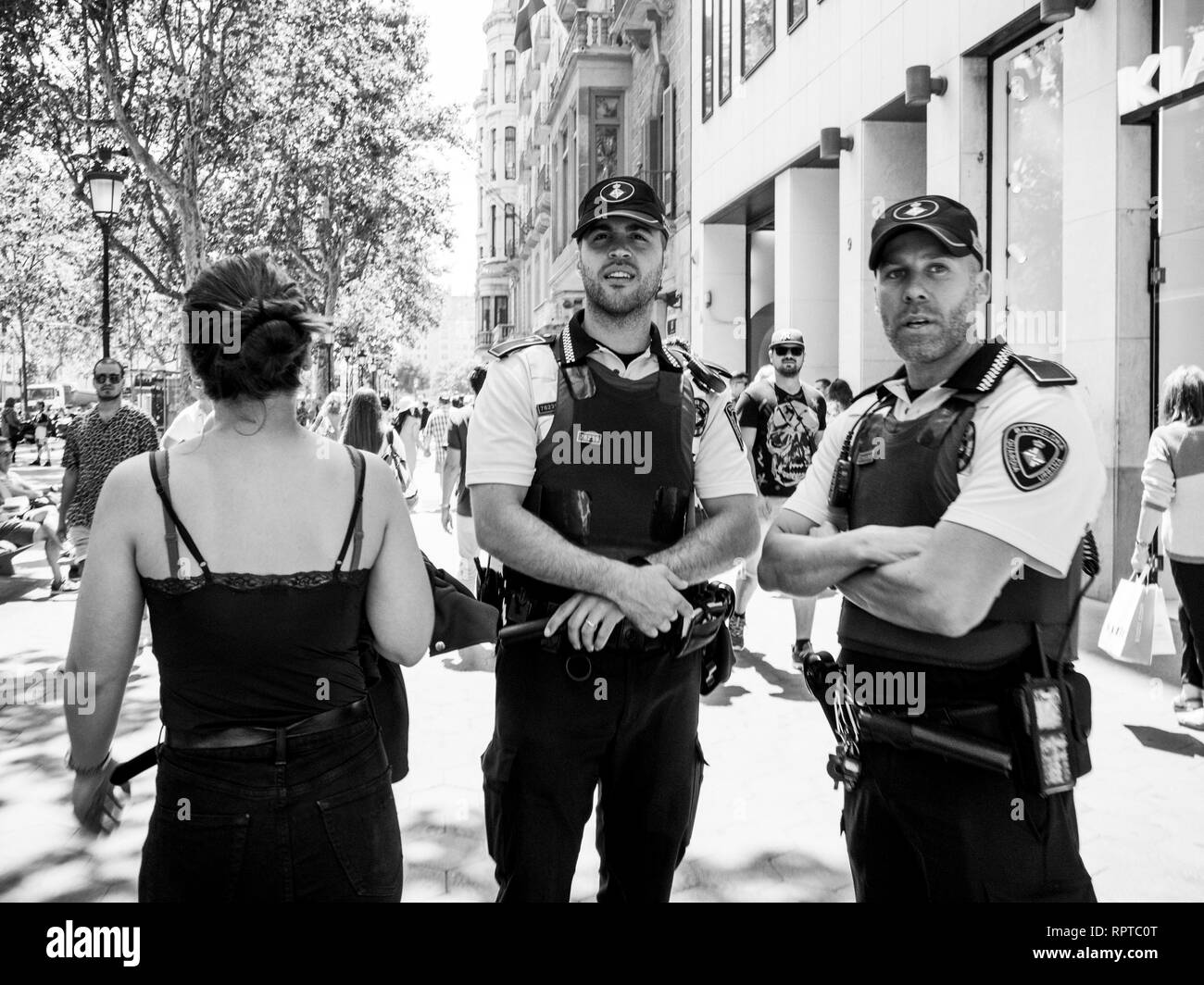 BARCELONA, España - jun 1, 2018: Policías surveilling gente en multitud de calles en de Barcelona, Avenida de Europa, cientos de personas se desplaza en un cálido día de trabajo