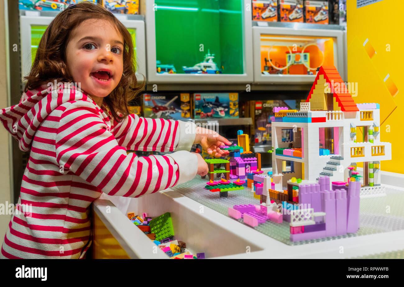 Bebé niña juegan con los ladrillos de Lego en el interior de la tienda de  Lego Fotografía de stock - Alamy
