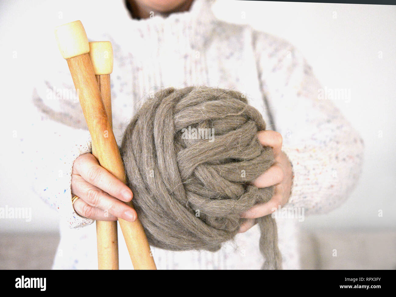 Mujer sosteniendo una bola de lana y agujas de tejer Foto de stock
