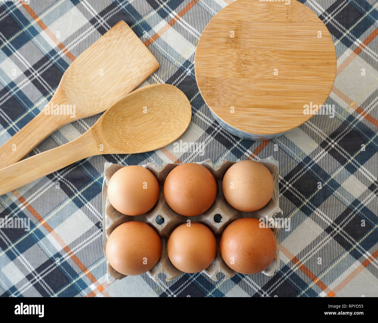 Accesorios de cocción de pasteles. Los huevos de pollo fresca cruda en caja  de huevo, cucharas de madera y contenedor de harina o azúcar Fotografía de  stock - Alamy