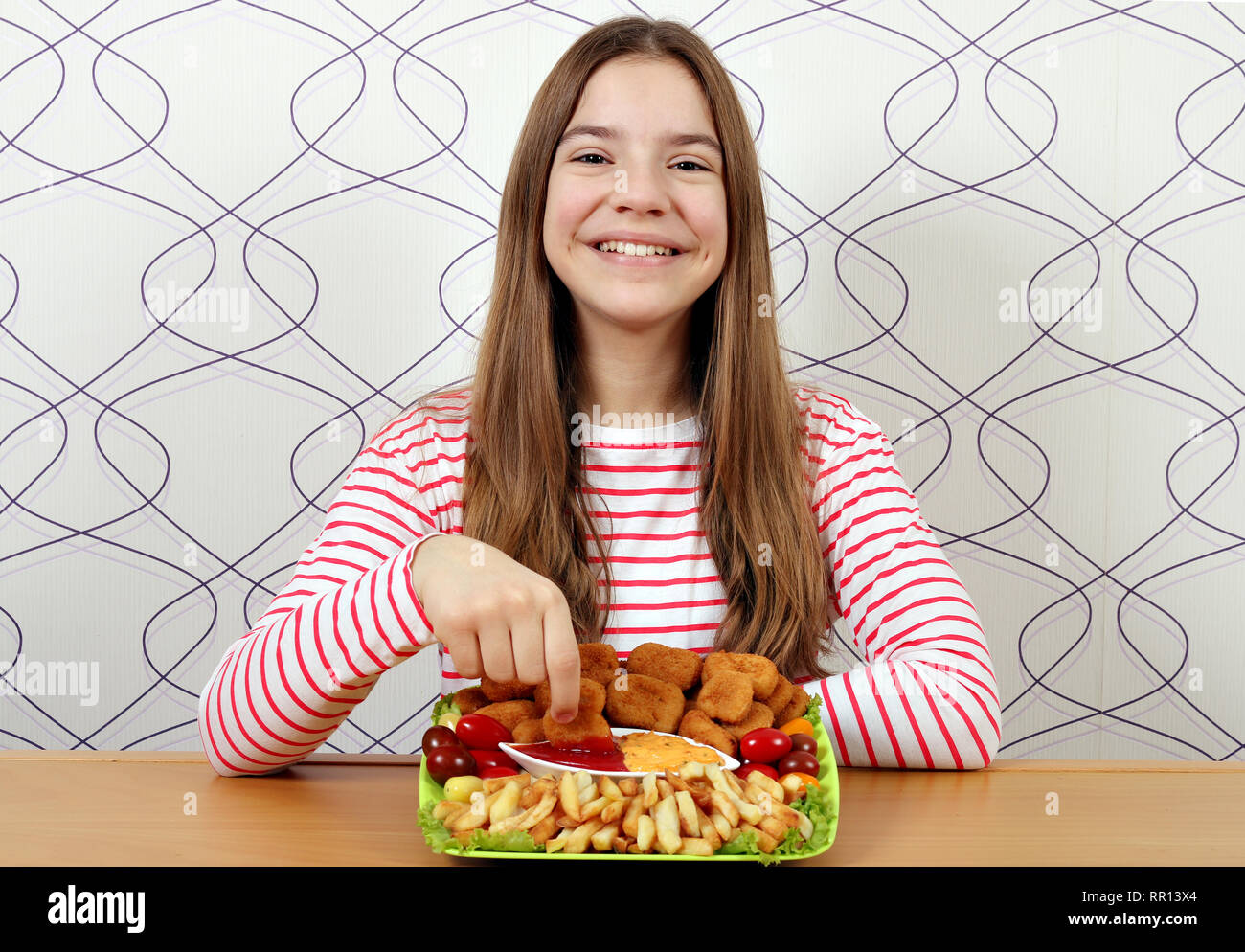 Feliz adolescente come nuggets de pollo con salsa de tomate Fotografía de  stock - Alamy