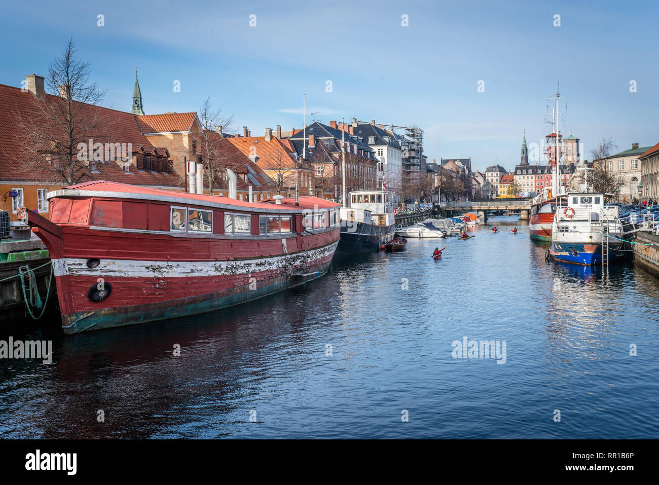 Los coloridos barcos en el canal con los palistas de Nyhavn en Copenhague Foto de stock