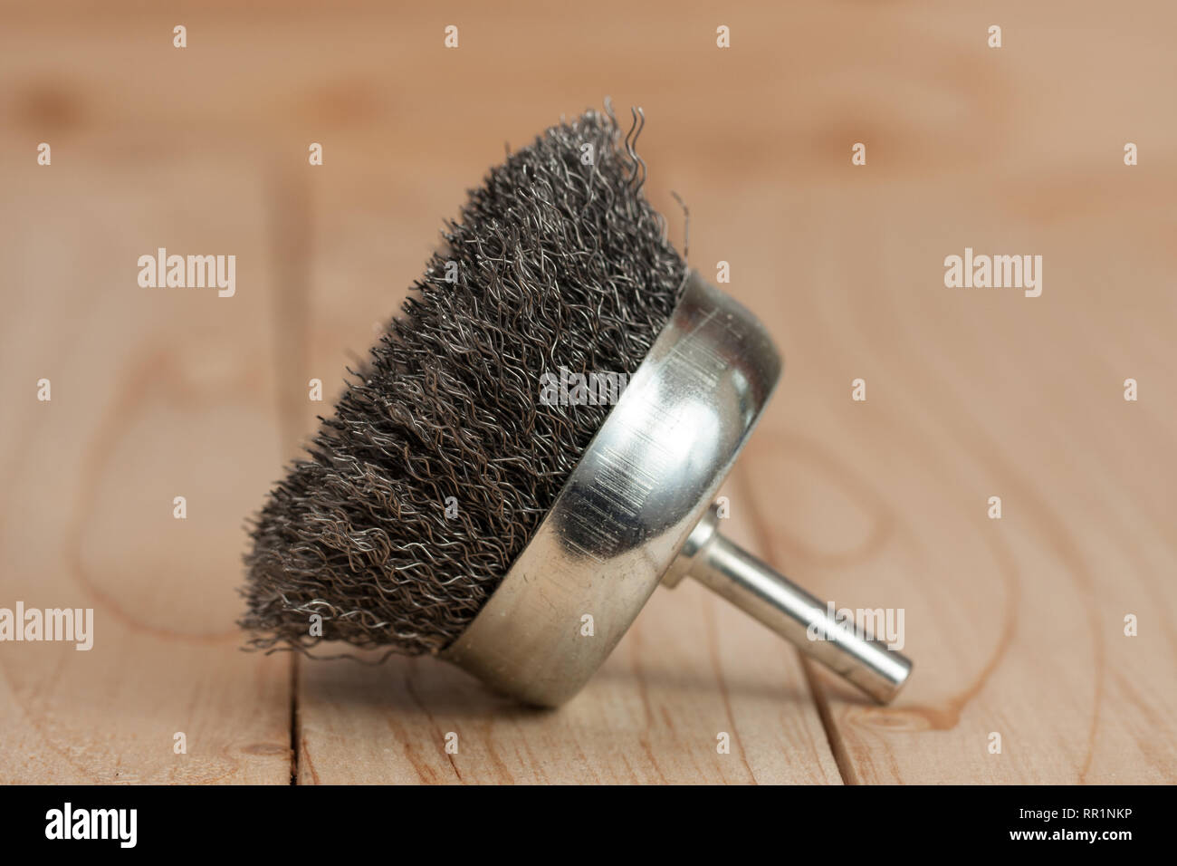 Cepillo de metal en un taladro para quitar el óxido sobre un fondo de  madera ligera Fotografía de stock - Alamy