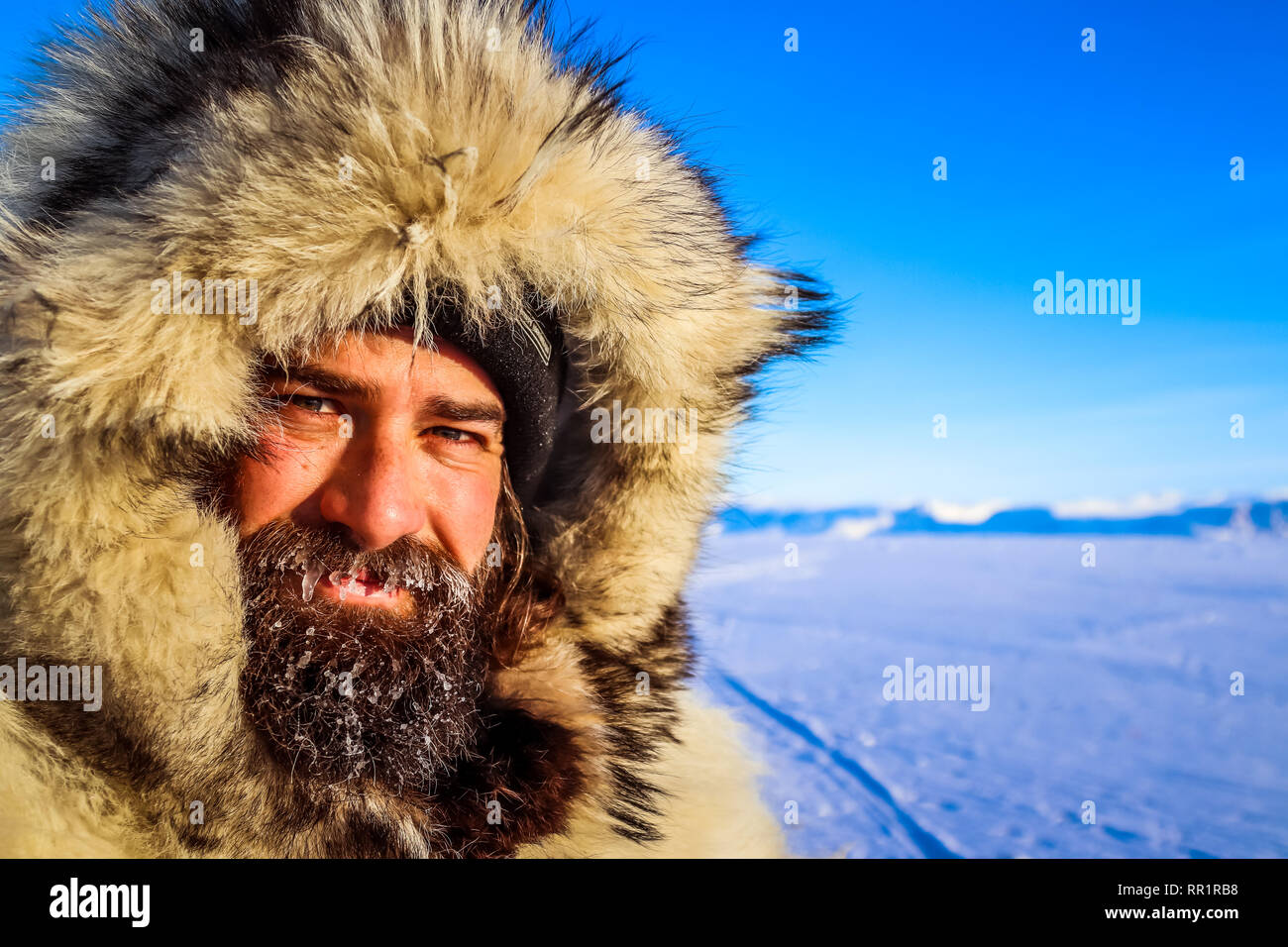 Hombre Barbado necesita más que vello facial para mantener advertir en el Ártico canadiense. Fotografiados aquí vistiendo un abrigo de de en el congelado de Cumberland Fotografía de