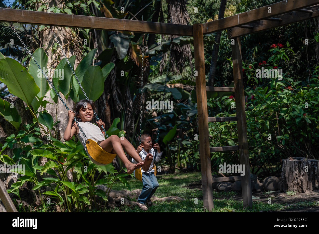 América hermanos jugando en los columpios en el patio de recreo de  Guatemala Fotografía de stock - Alamy