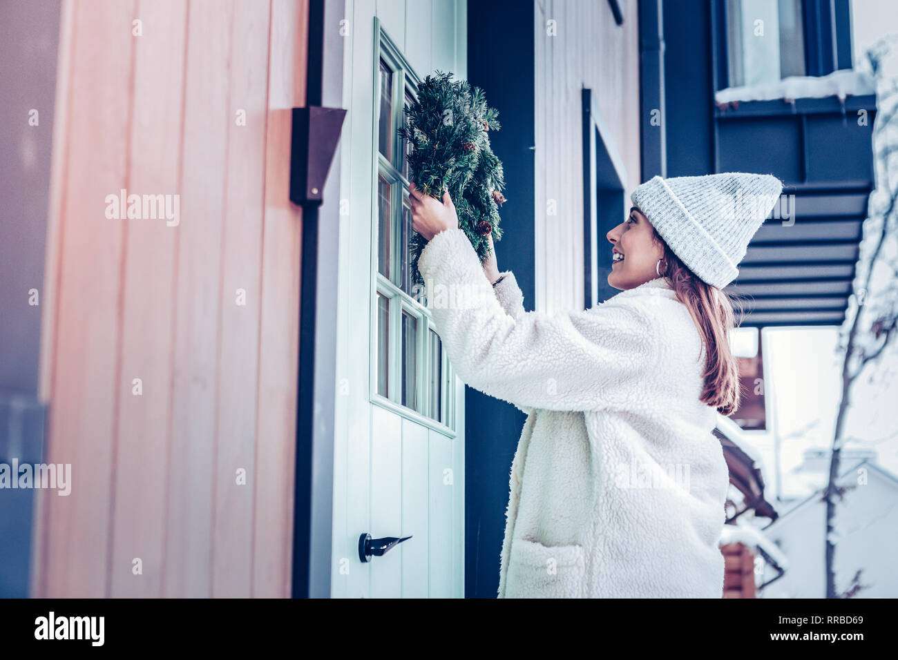 Mujer vistiendo abrigo beige cálidos decorando la parte frontal de la casa  Fotografía de stock - Alamy