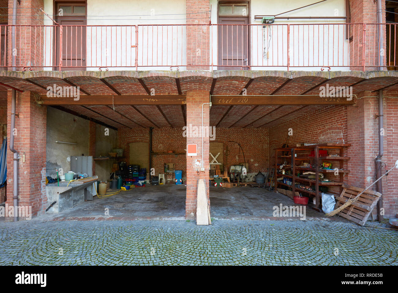 Antigua casa de campo con depósito desordenado y paredes de ladrillo en un día soleado de verano en Italia Foto de stock