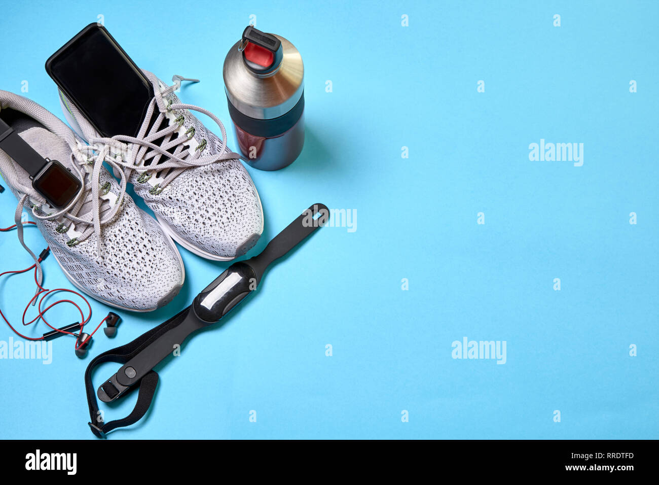 Zapatillas con accesorios tecnológicos y junto a un barco de agua sobre un  fondo azul Fotografía de stock - Alamy