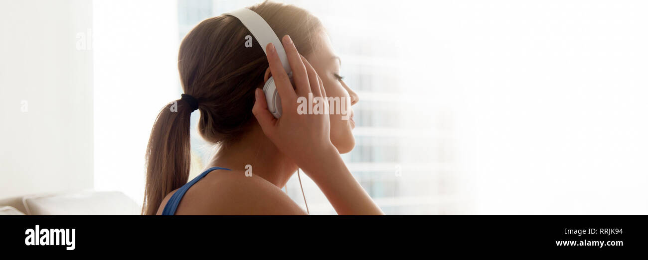 Vista lateral con los auriculares puestos femeninos disfruta de tu música favorita en casa Foto de stock
