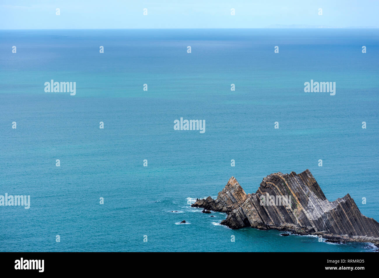 Hermoso mar azul increíble agua del océano y el blanco limpio cielo nuboso. Escarpado acantilado rock island al borde del mar en calma Foto de stock