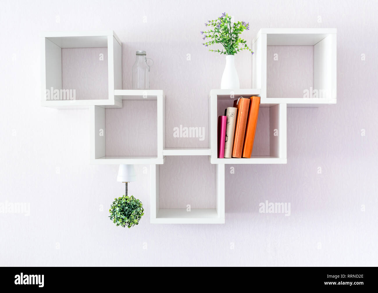 https://c8.alamy.com/compes/rrnd2e/una-moderna-estanteria-blanca-sobre-una-pared-blanca-con-un-par-de-libros-y-flores-el-minimalismo-estilo-rrnd2e.jpg