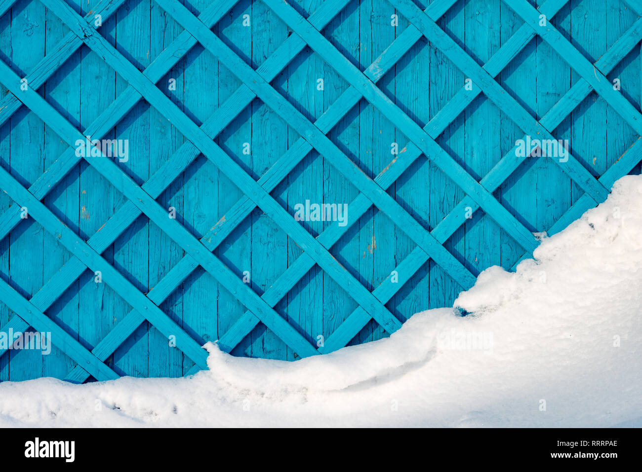 Valla de madera cubierto con nieve blanca. Patrón de color azul de tablones Foto de stock