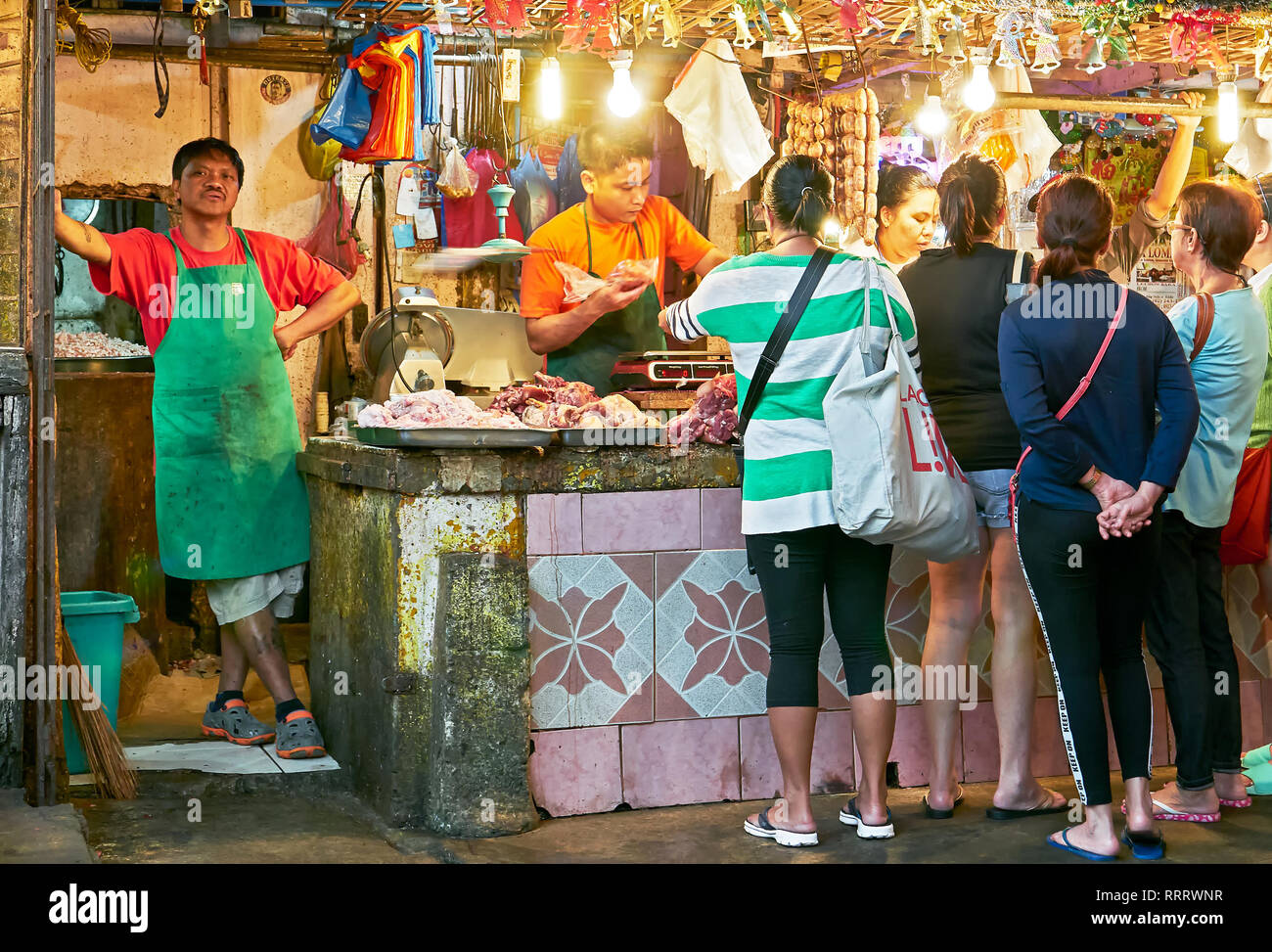 La ciudad de Baguio, Filipinas, provincia de Benguet - Diciembre 26, 2017: el grupo de mujeres la compra de carne en un establo en el centro Wet Market, el jefe viendo Foto de stock