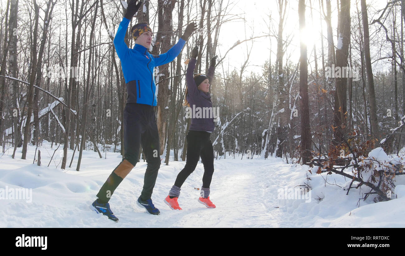 Pareja joven calentamiento en invierno bosque Foto de stock