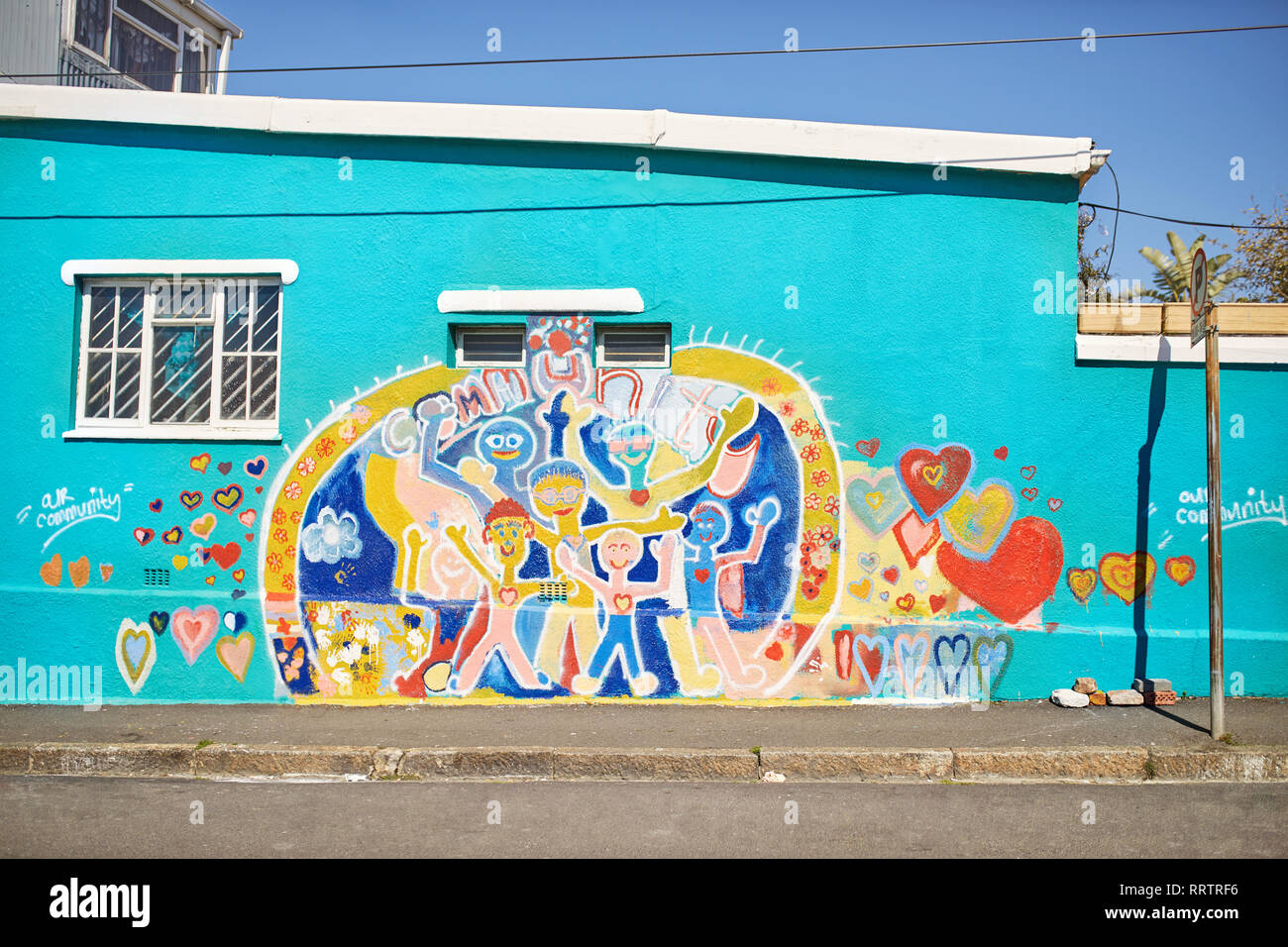 Comunidad vibrante mural sobre pared urbana soleado Foto de stock