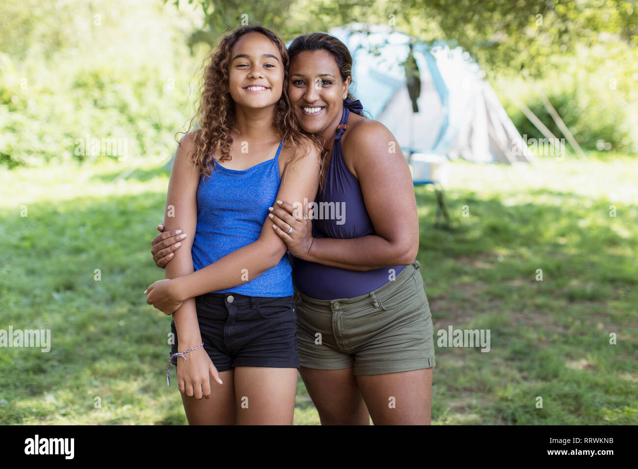 Retrato feliz, cariñoso, madre e hija en camping Foto de stock