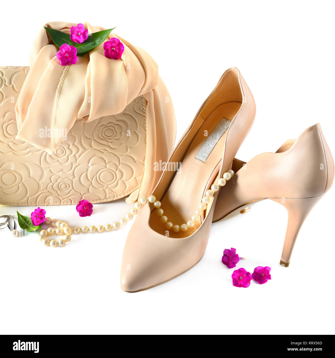 Elegante zapatos femeninos, pequeño bolso, pañuelo para el cuello y perla  aislado sobre fondo blanco. Un juego de accesorios en color beige de colores  pastel Fotografía de stock - Alamy