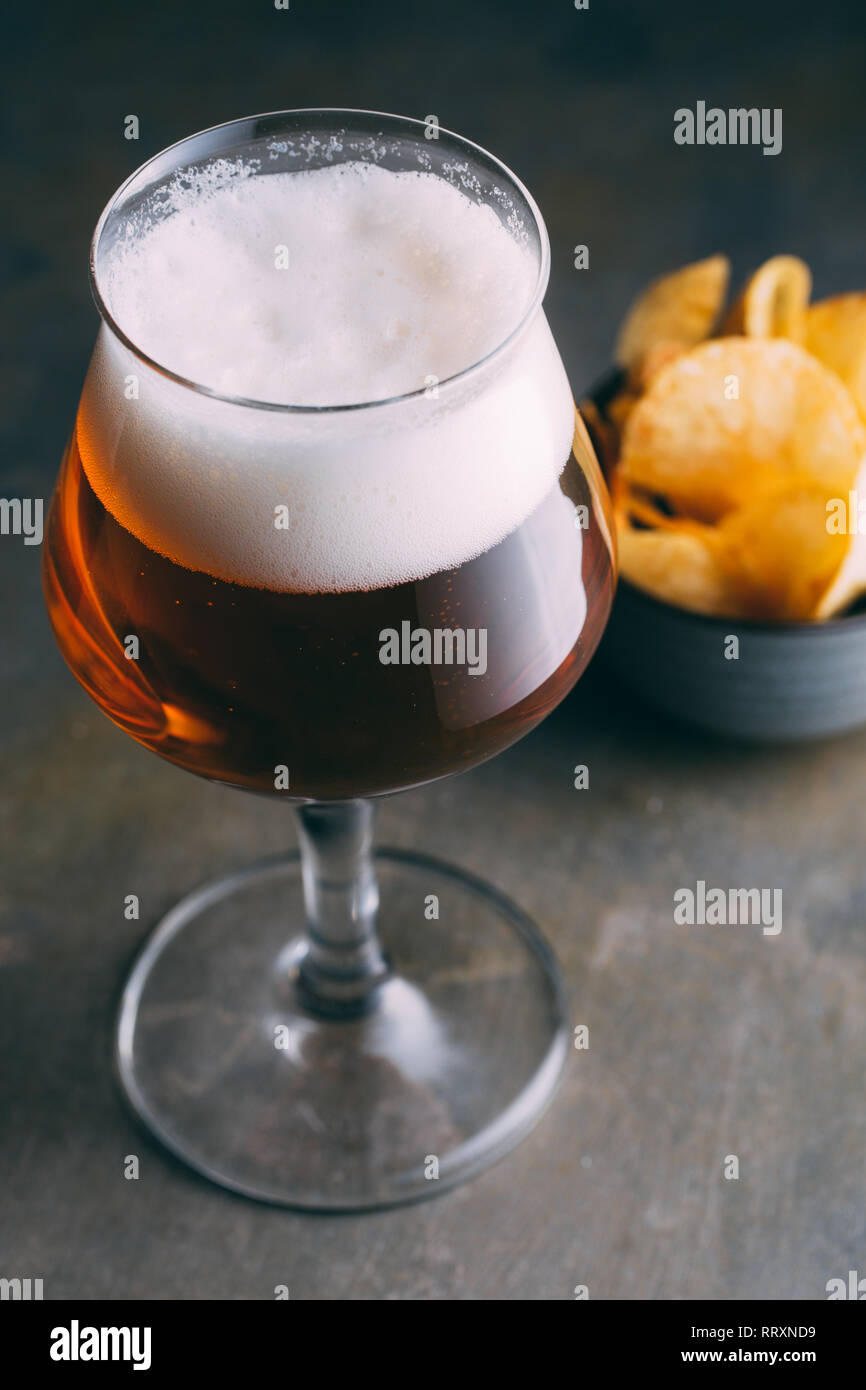 Vaso de cerveza y patatas fritas en oscuro y Grunge antecedentes Foto de stock