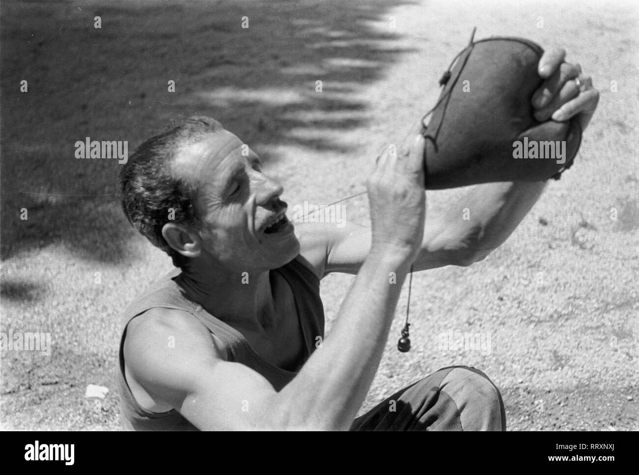 España - Spanien ca.1950, Mann mit Wasserschlauch an der Costa Brava Foto de stock