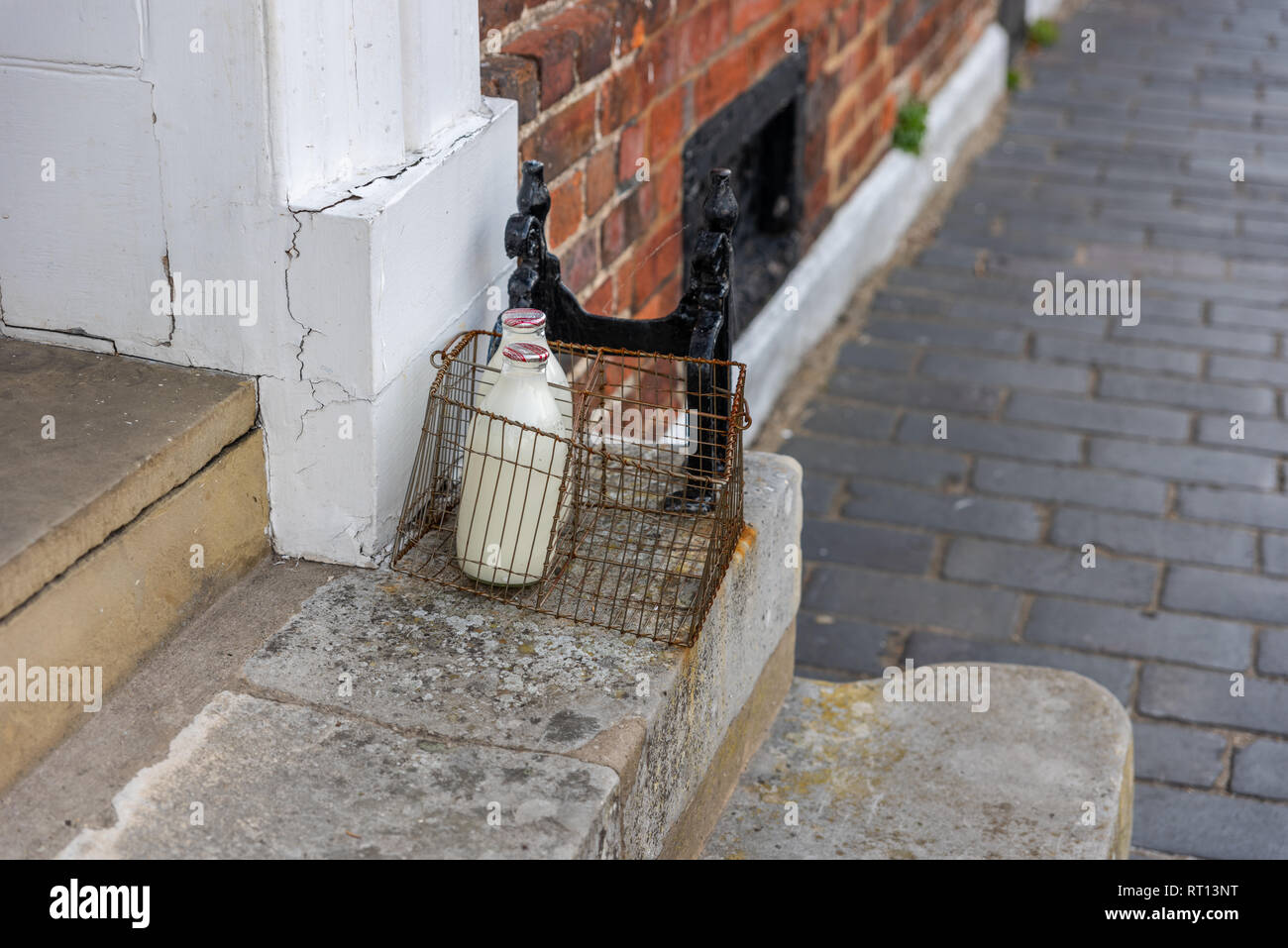 Dos botellas de leche y una rasqueta de arranque Victoriano en un hotel en St Albans, Hertfordshire, Inglaterra Foto de stock