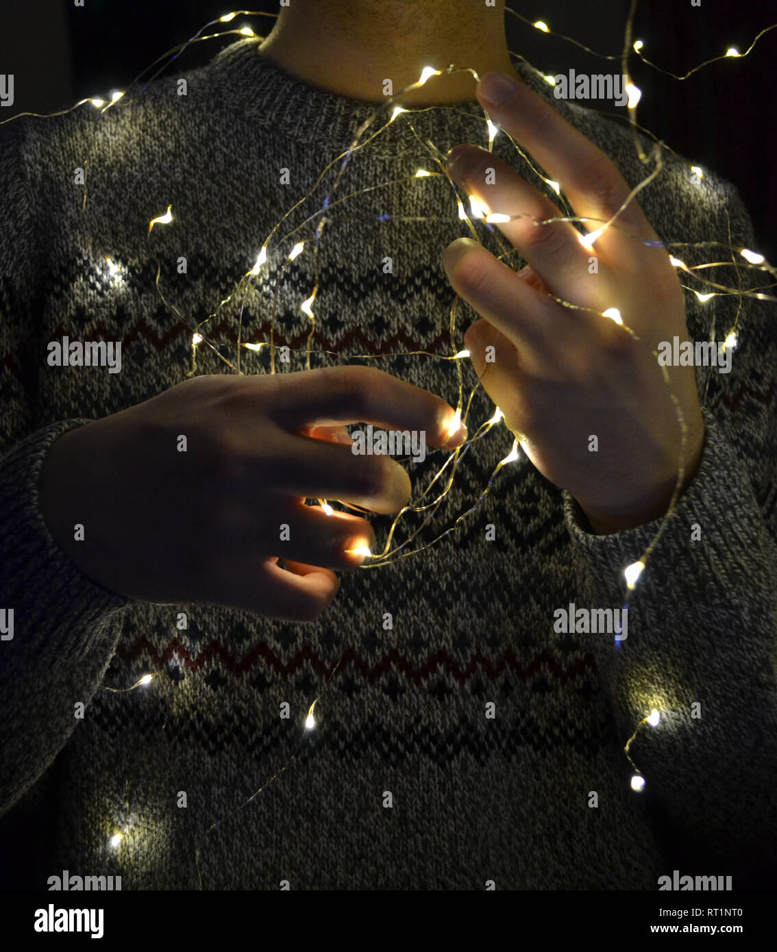 Las luces de Navidad en las manos del hombre. Las manos del hombre la celebración de led luces de cadena Foto de stock