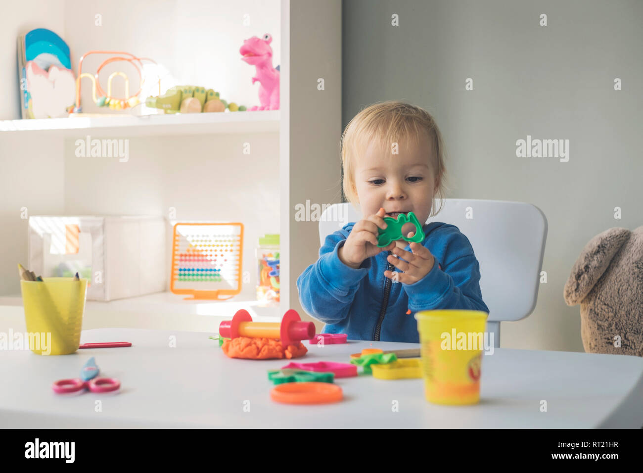 Retrato de bebé niña jugando con cortador y plastilina Foto de stock