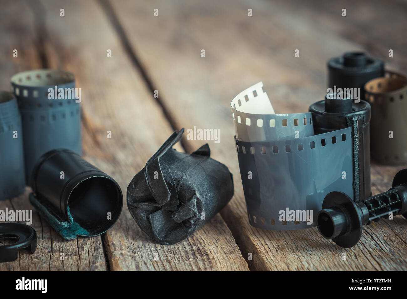 Los rollos de película fotográfica vintage y el casete en el viejo escritorio de madera. Tonos retro. Foto de stock