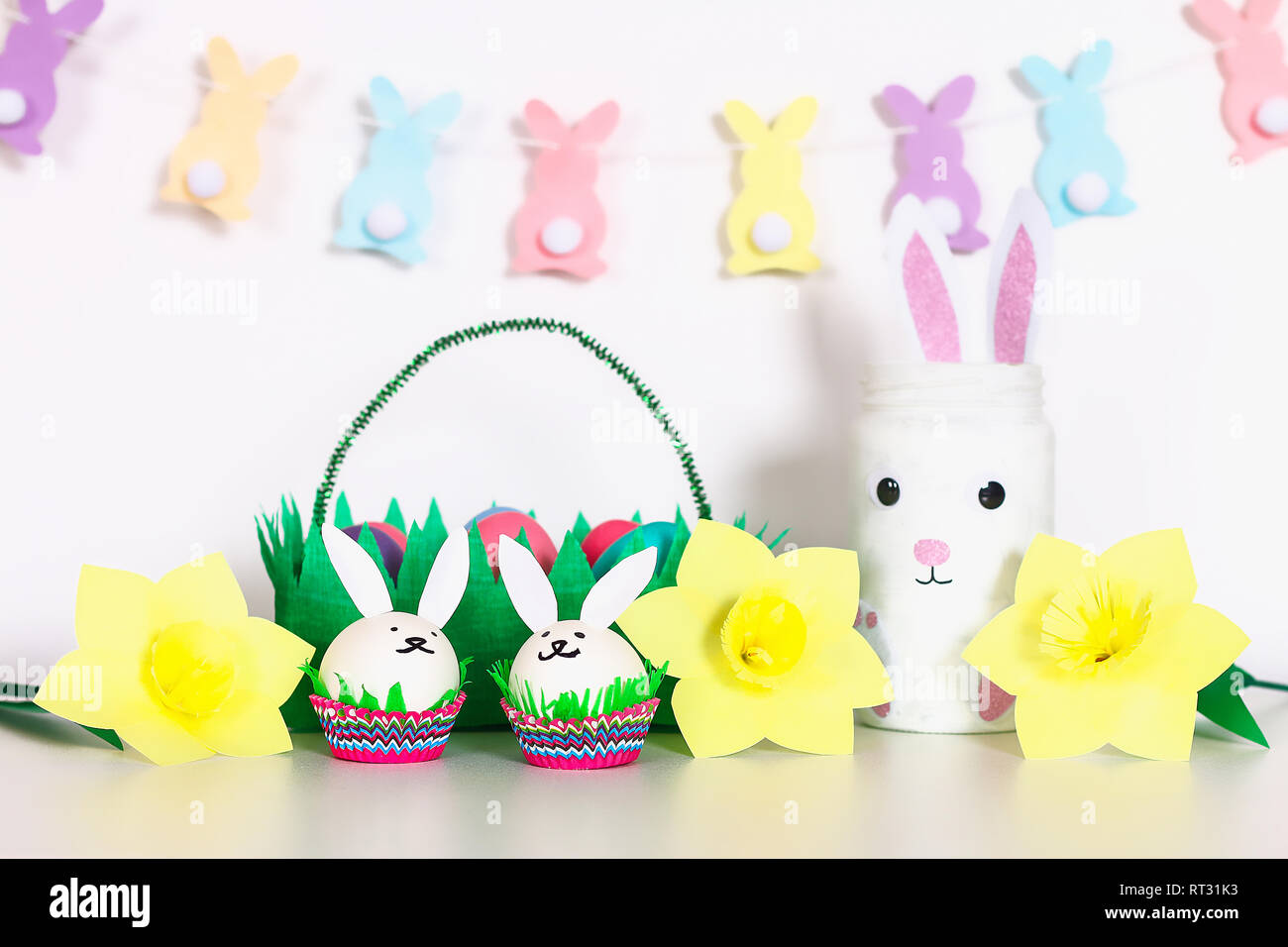 Bricolaje decoración para Pascua. Guirnaldas de papel, vase bunny,  narcisos, huevos, conejitos, cesta con huevos pintados. Decoración de la  Mesa, blanco, hogar para la Pascua, la primavera Fotografía de stock - Alamy