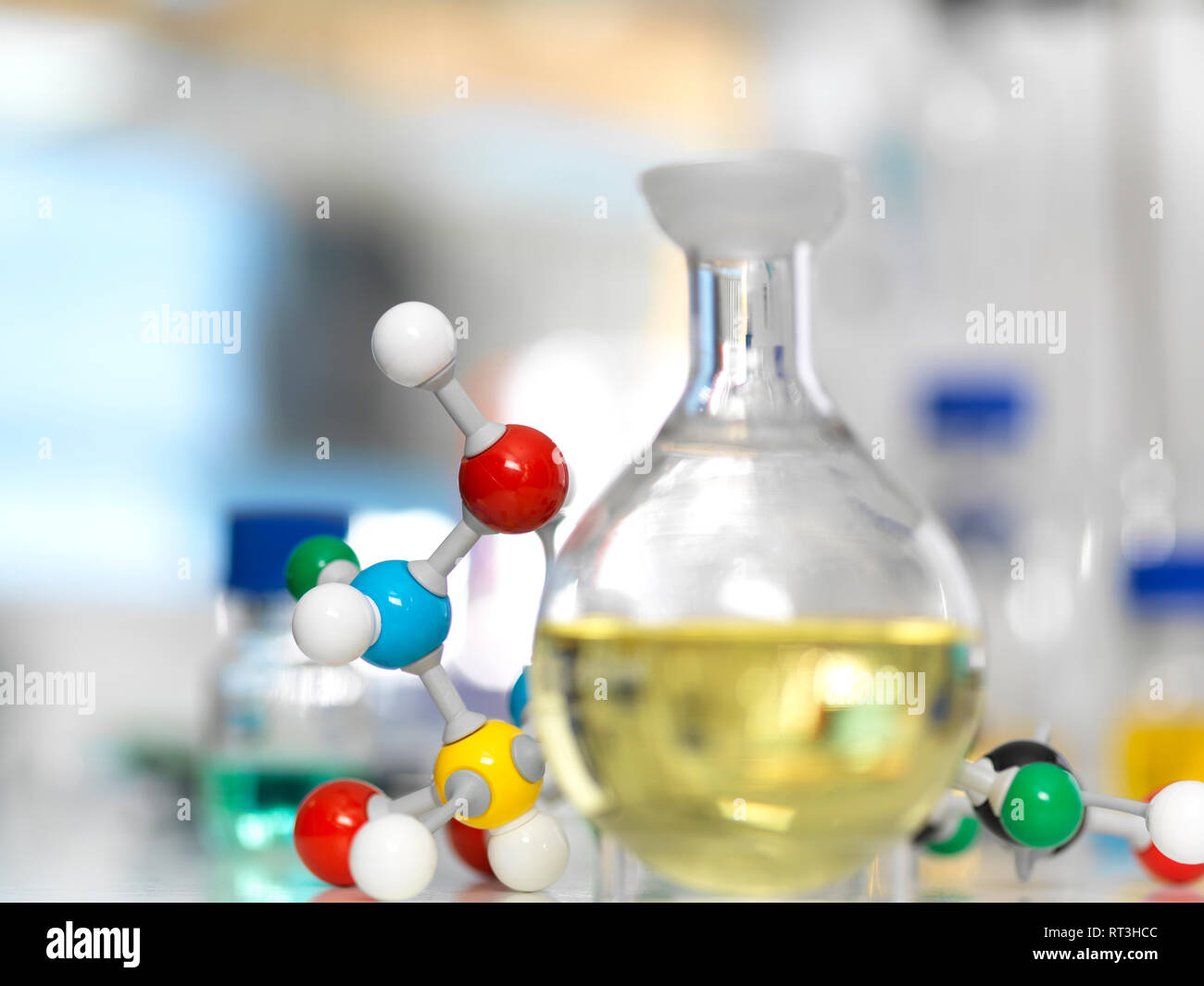 Matraz que contenga una fórmula química junto al modelo de molécula Foto de stock