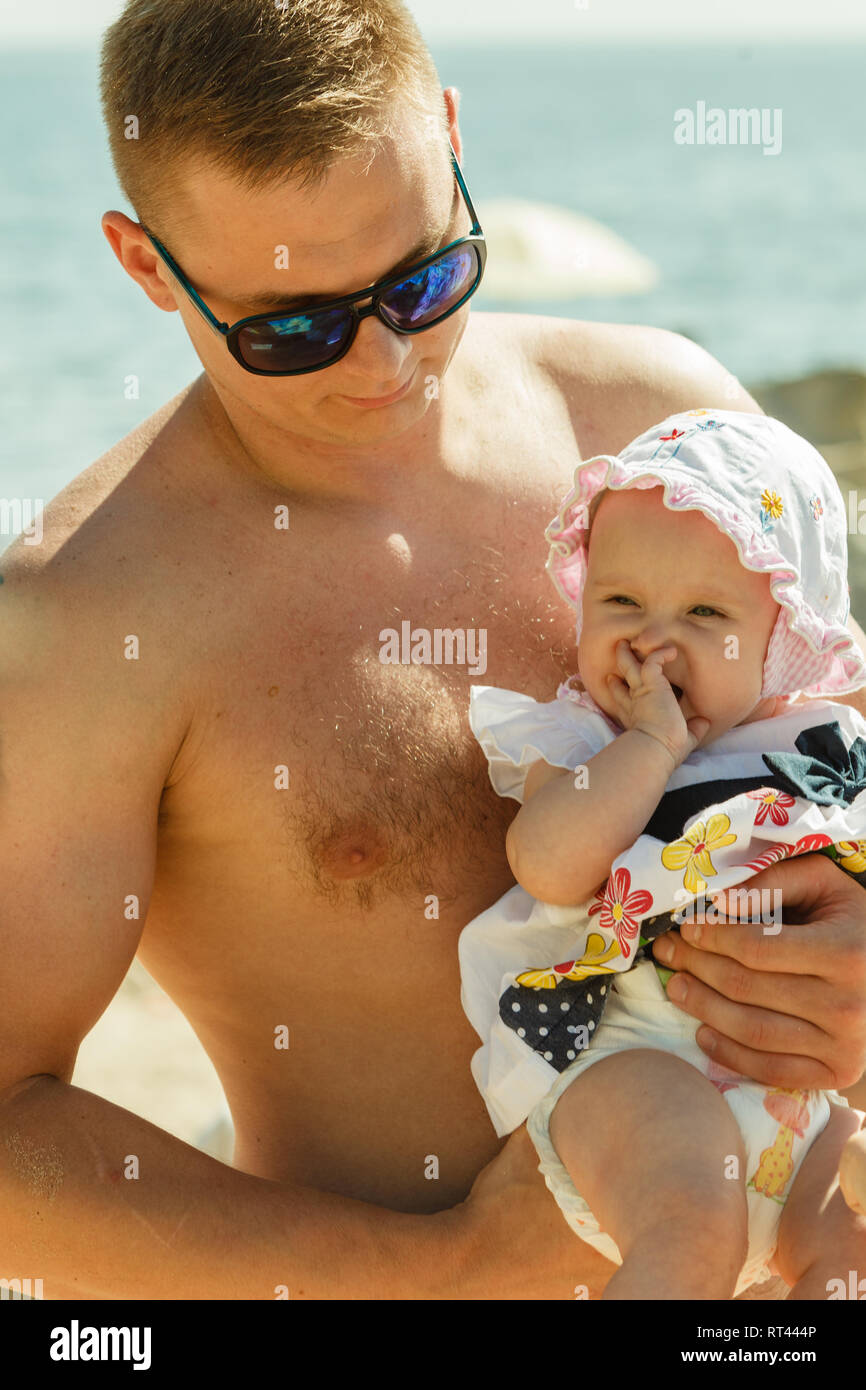 Padre sosteniendo bebé posando en en día soleado Fotografía de stock - Alamy
