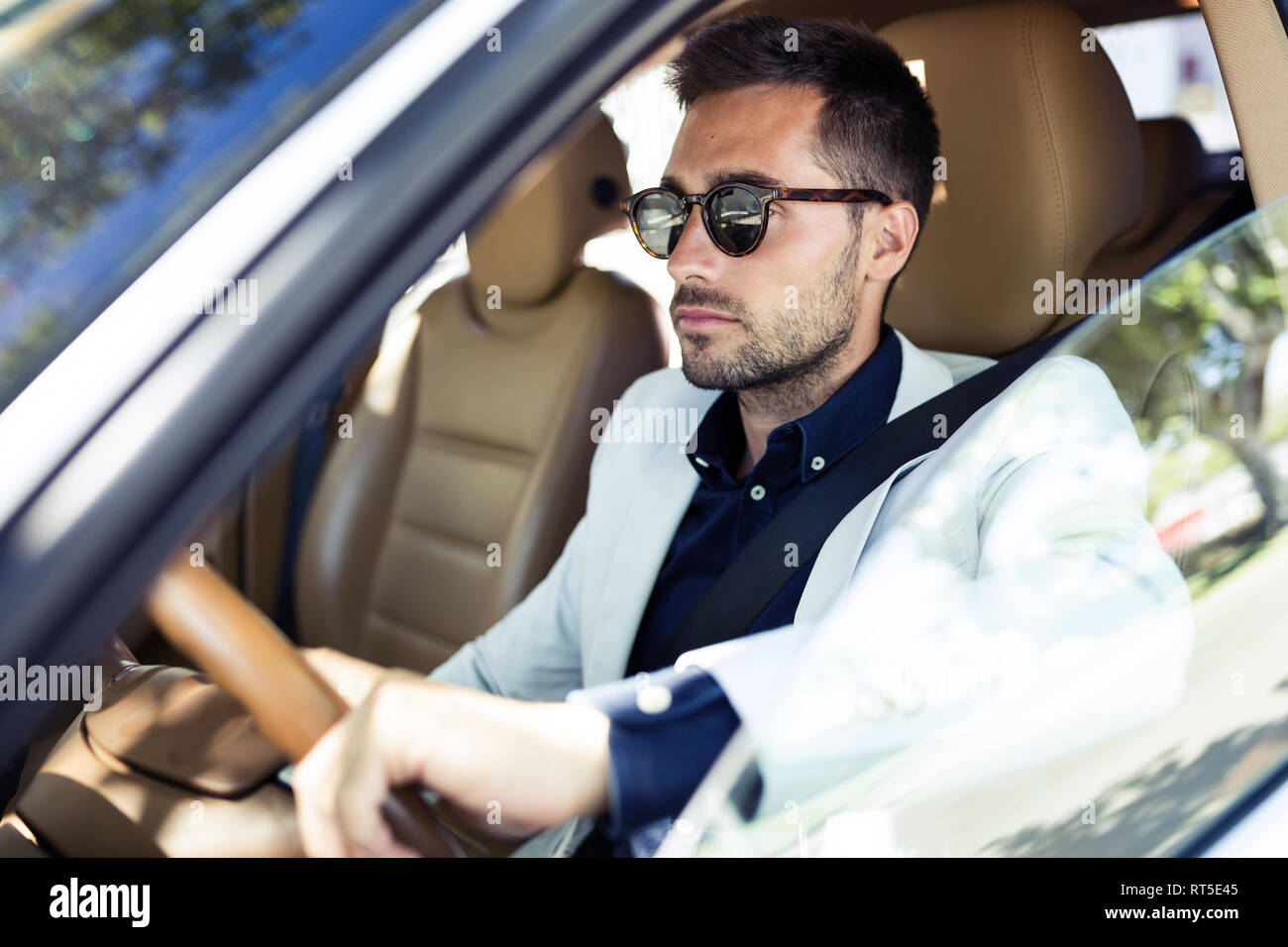 Joven empresario exitoso circulando en su coche Foto de stock