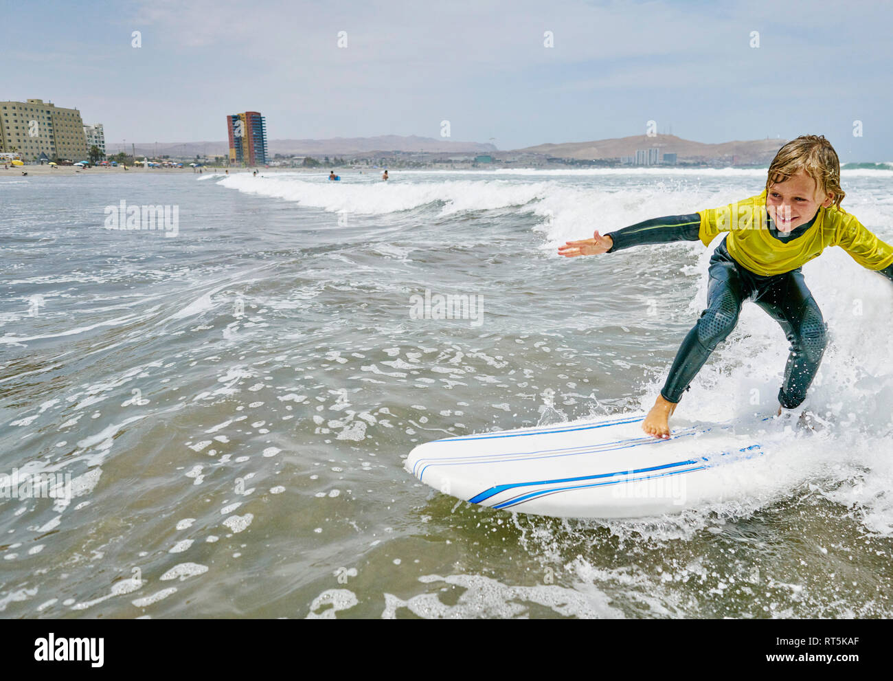 Chile, Arica, muchacho feliz surf en el mar Foto de stock