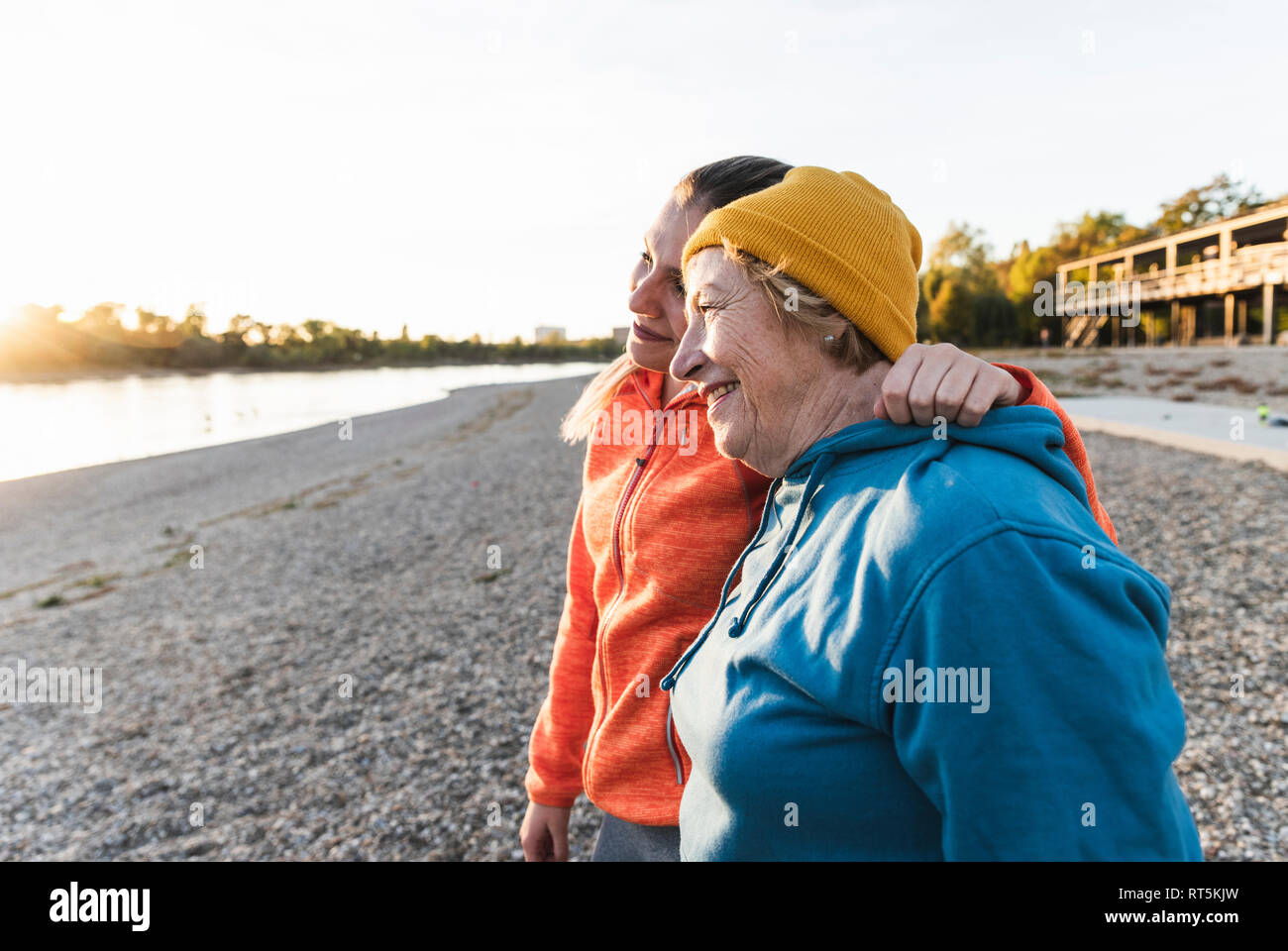 Colocar abuela y nieta caminando en el río con los brazos alrededor, divertirse Foto de stock