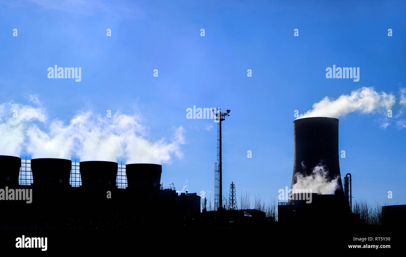 Polígono Industrial mostrando la torre de refrigeración y chimeneas recortadas contra el cielo azul en el sitio de producción química BASF en el puerto de Antwerp, Bélgica. Foto de stock