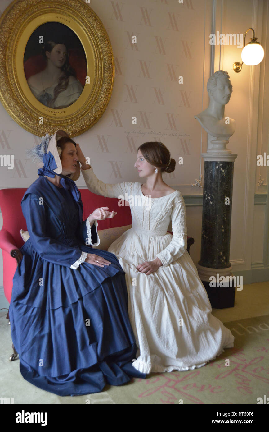 Dos mujeres en la época victoriana en vestidos sentarse y charlar en un  salón formal en Kensington. Uno es un joven Reina Victoria y la otra es la  Baronesa Lehzen Fotografía de