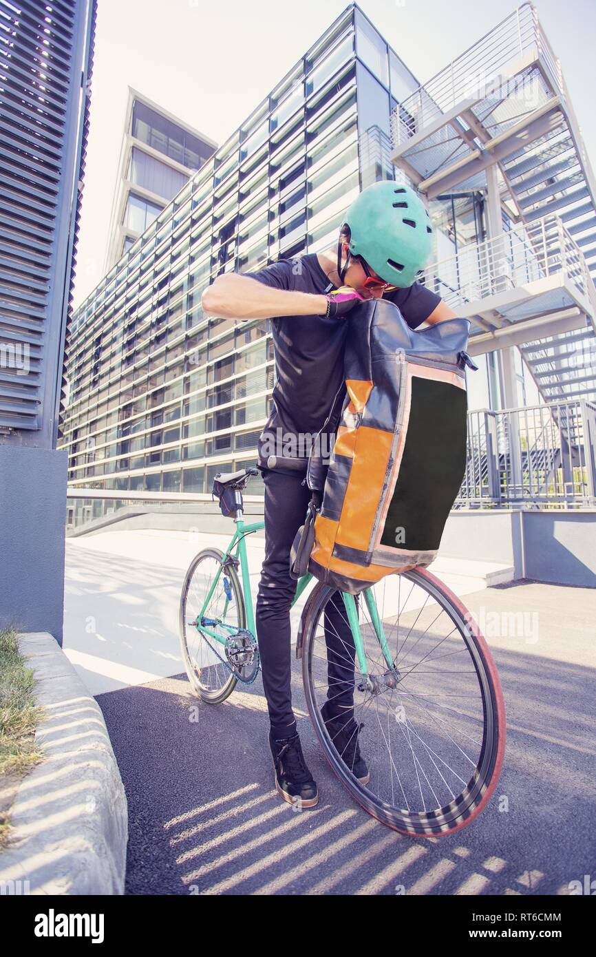 Bike messenger con enorme mochila en la ciudad Fotograf a de stock