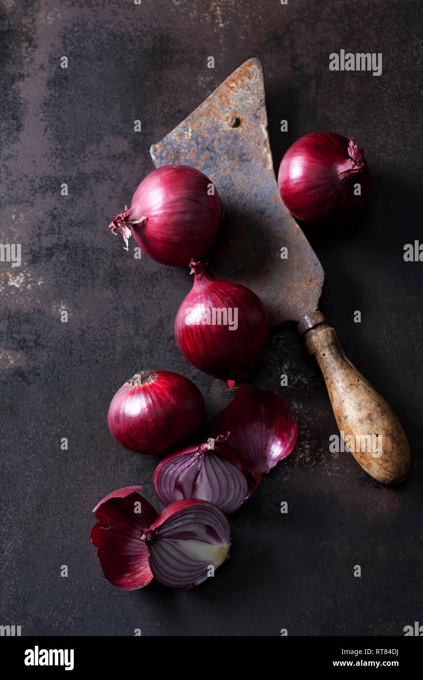 Conjunto y rodajas de cebolla roja y un oxidado cleaver Foto de stock