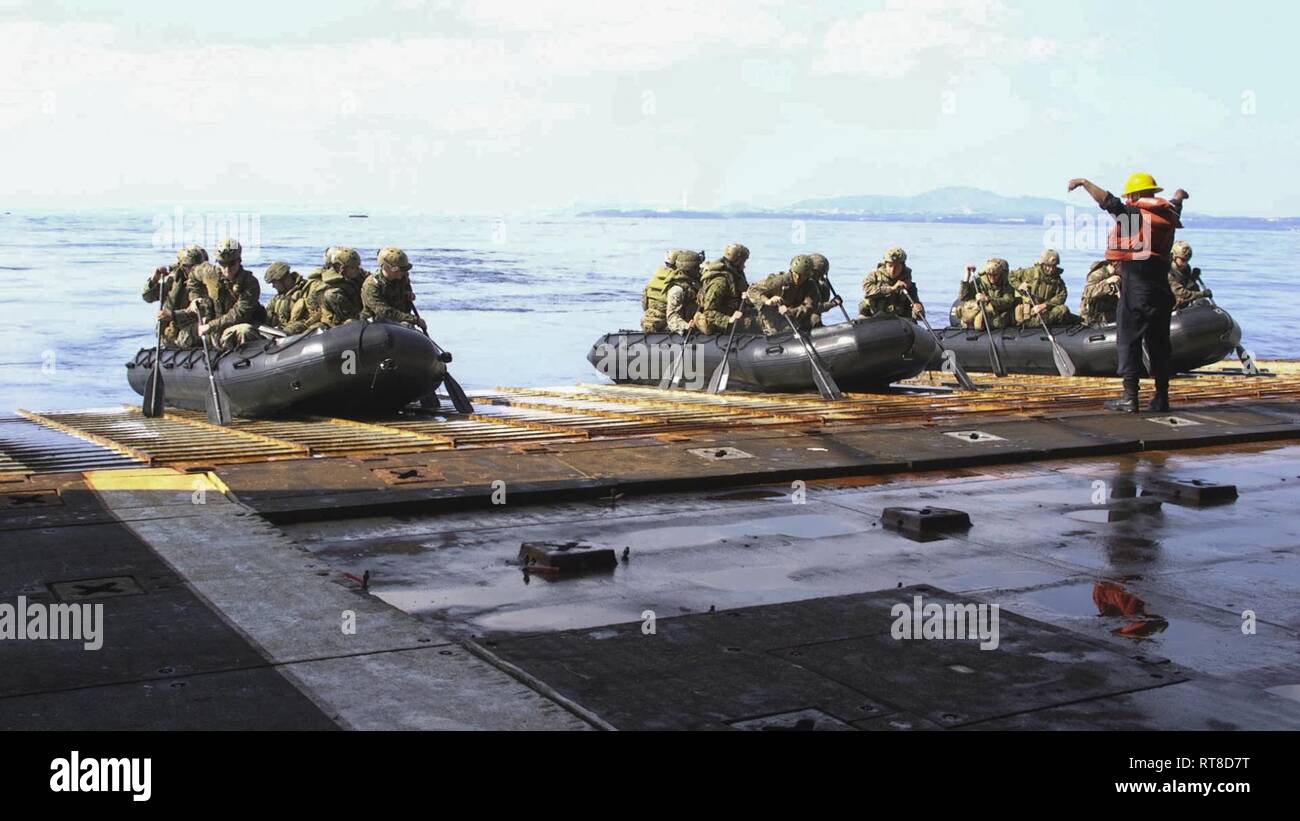 Los infantes de marina con alfa-Empresa, Equipo de aterrizaje del Batallón, 1er Batallón, 4º Marines, esperar para iniciar su combate atacando goma manualidades a bordo de la nave de aterrizaje dock USS Ashland (LSD 48), Mar de Filipinas, 25 ene, 2019. BLT 1/4 es el elemento de combate en tierra para la 31ª Unidad Expedicionaria de los Infantes de Marina. La 31ª MEU, el Marine Corps" sólo desplegadas continuamente MEU asociarse con Wasp ARG, proporciona una flexibilidad y fuerza letal listo para realizar una amplia gama de operaciones militares como la principal fuerza de respuesta a la crisis en la región del Indopacífico. Foto de stock