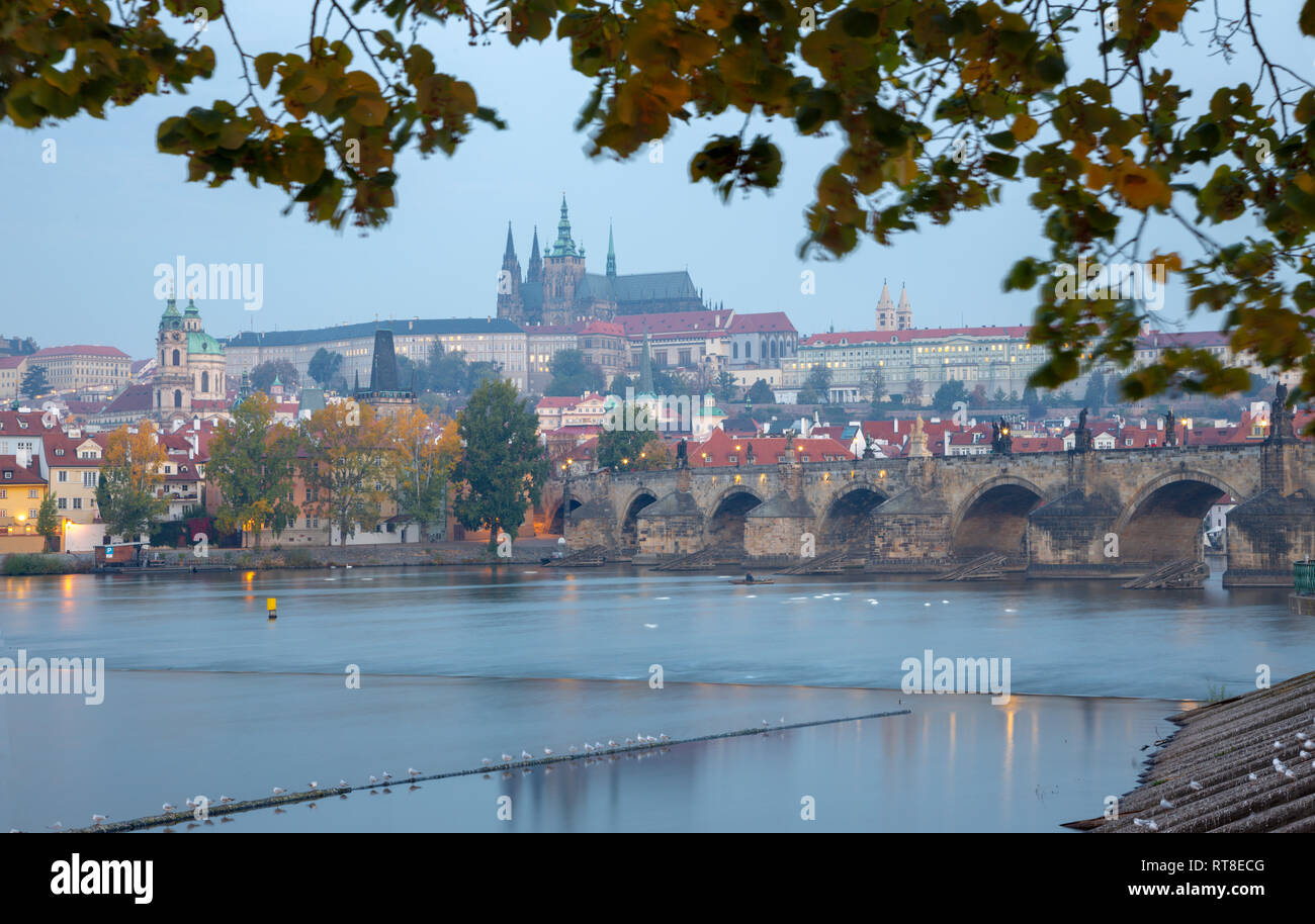 Praga - El Puente de Carlos, el castillo y la catedral desde el paseo sobre el río Vltava a la mañana al anochecer. Foto de stock