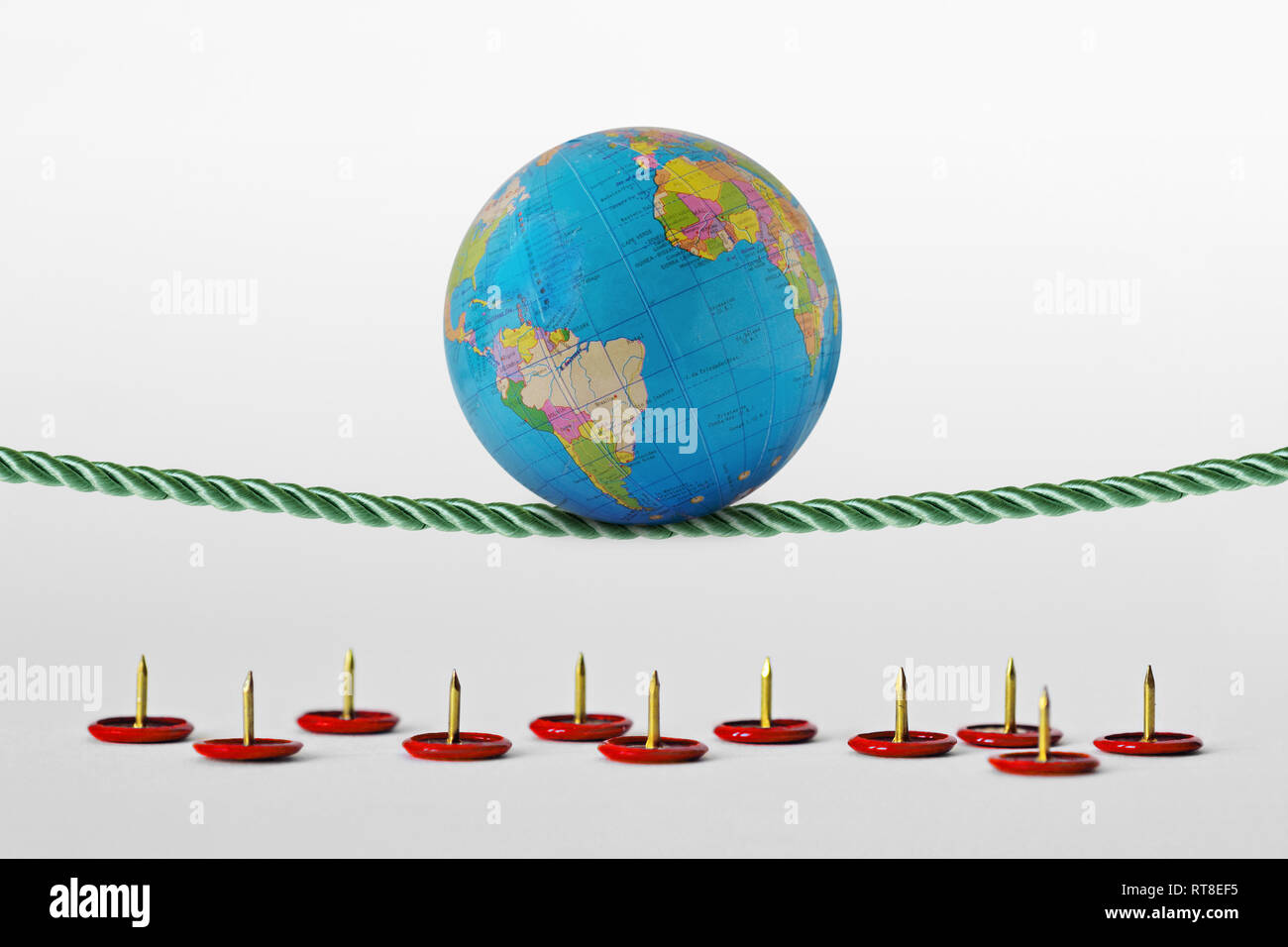 Planeta tierra el equilibrio sobre la cuerda más chinchetas - Concepto de Planeta Salud y riesgos ambientales Foto de stock