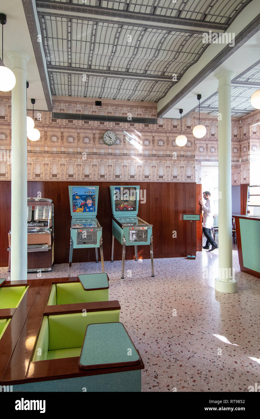 Máquinas de pinball, el juke box y mobiliario color pastel en el Bar Luce, Wes Anderson-bar y cafetería inspirada en la Fondazione Prada distrito de Milan, Italia. Foto de stock