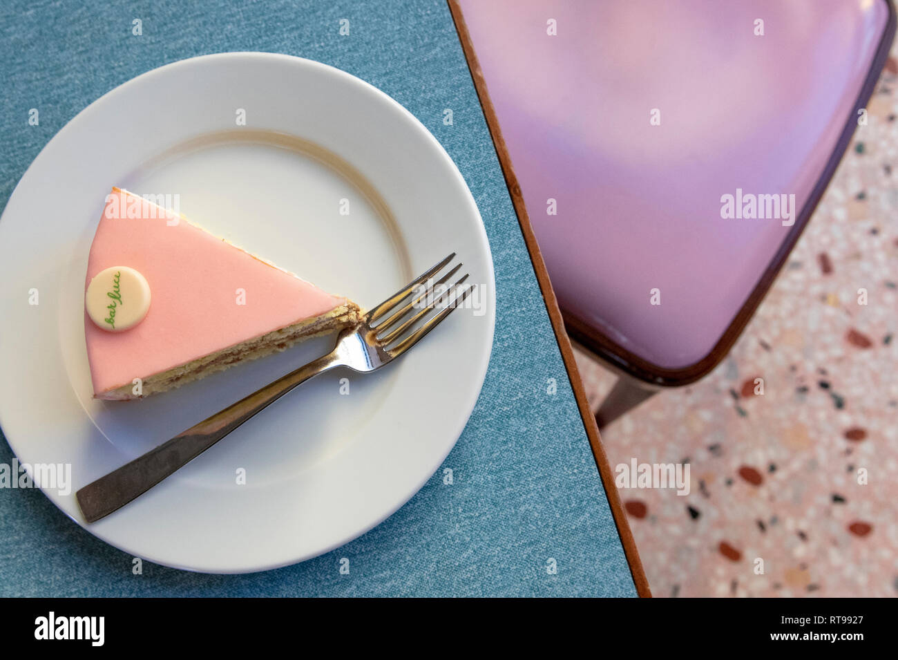 Un trozo de torta rosa pastel y mobiliario en el Bar Luce, Wes Anderson-bar y cafetería inspirada en la Fondazione Prada distrito de Milan, Italia. Foto de stock