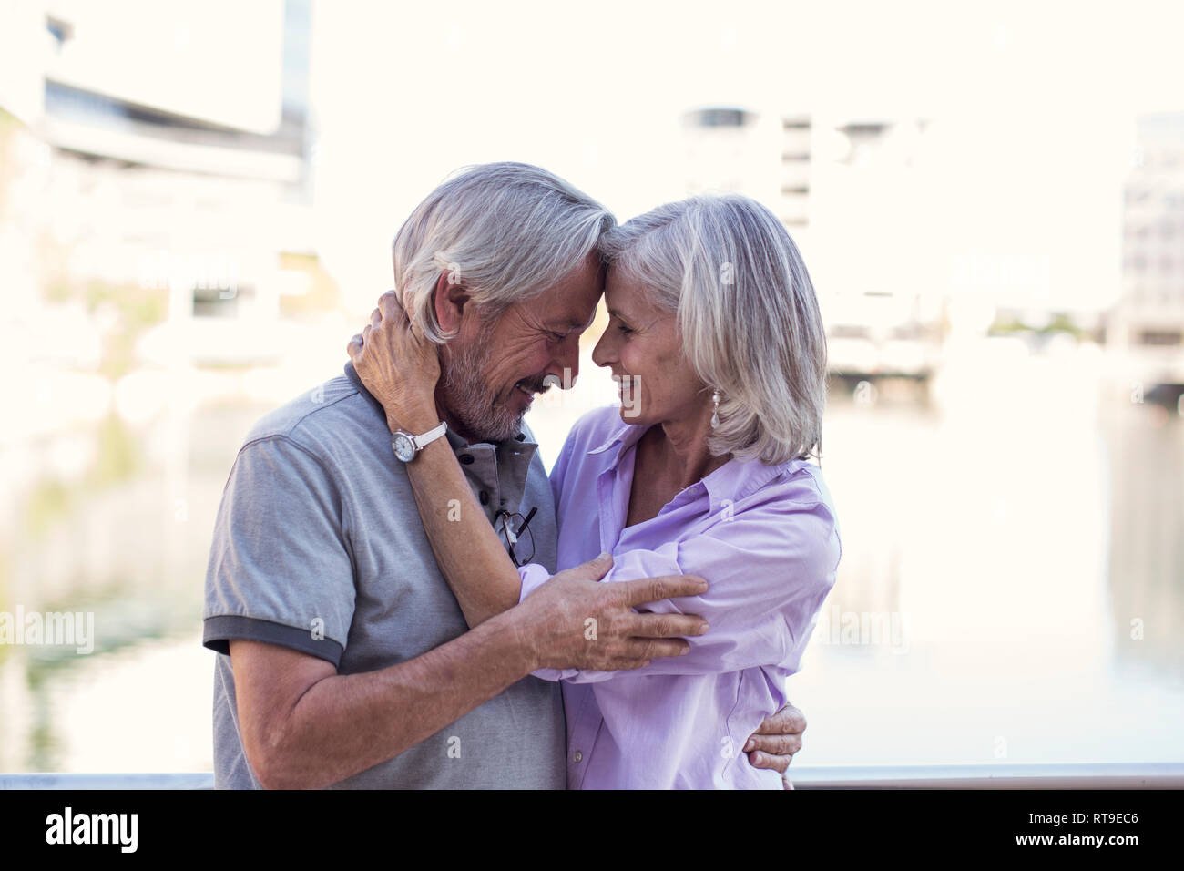 Las parejas ancianas tomando un descanso en la ciudad, besarse y abrazar Foto de stock