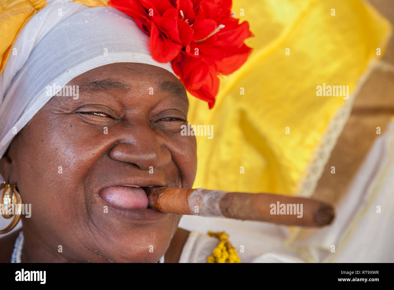 La Habana, Cuba - 24 de enero de 2013: Retratos del pueblo cubano en  vestidos tradicionales. Una anciana mujer afro-cubanos con un pañuelo  floreado cigarro cubano Fotografía de stock - Alamy