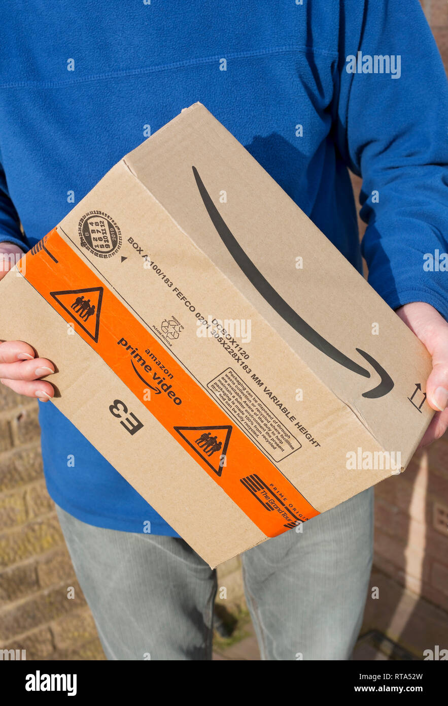Primer plano de hombre persona que sostiene Amazon prime video box paquete  home delivery shopping Inglaterra Reino Unido GB Gran Bretaña Fotografía de  stock - Alamy