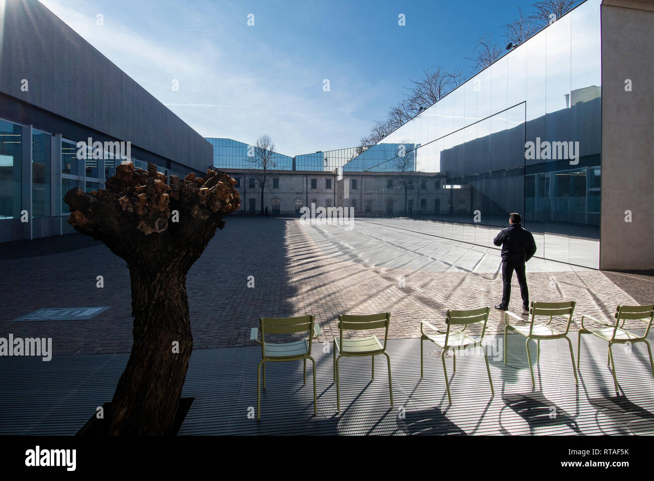 Hombre de pie en uno de los patios de la Fondazione Prada, exterior, Milan, Italia. Foto de stock
