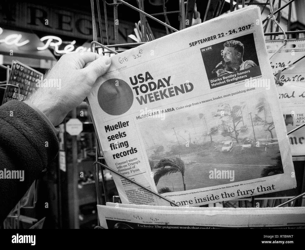 París, Francia - 23 Sep, 2017: hombre compra último diario USA TODAY con el huracán Maria Breaking news e imagen de daños de agua de mar de viento Foto de stock