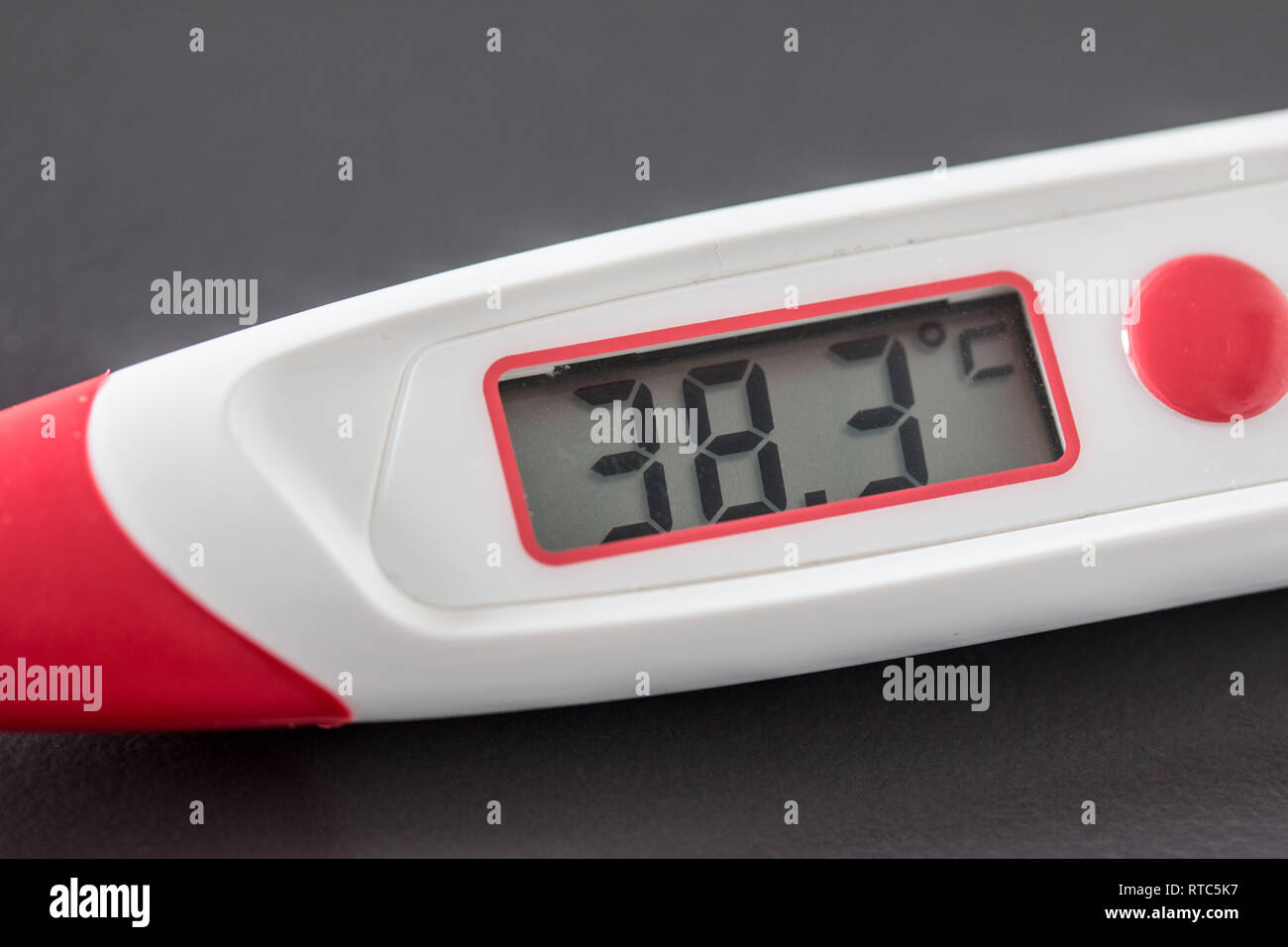 Fiebre roja termómetro con pantalla digital y 38 grados centígrados,  recostada sobre el escritorio Fotografía de stock - Alamy