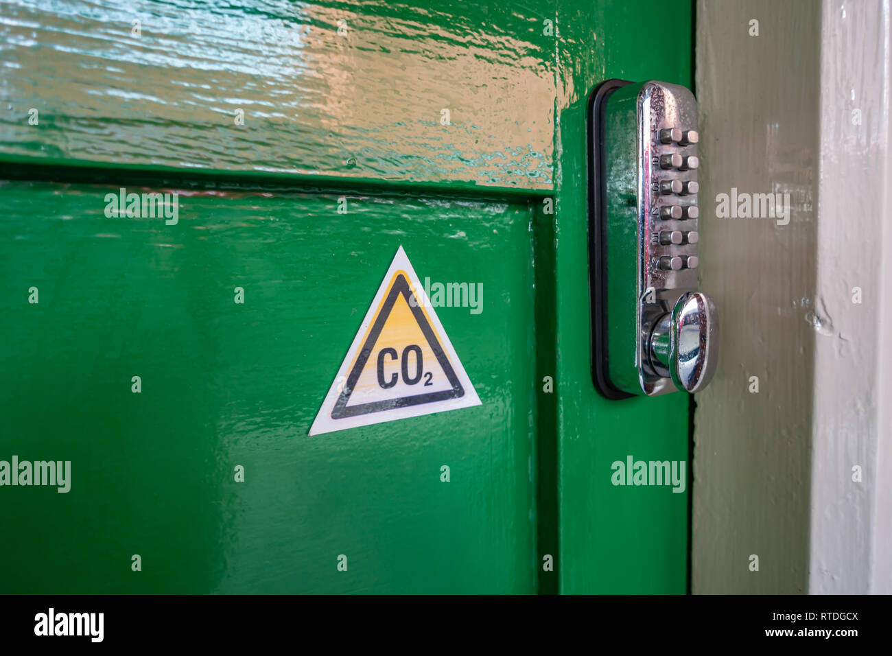 Triángulo de CO2 la señal de advertencia y la cerradura de la puerta del  teclado digital sobre una antigua puerta de madera verde en la estación de  Doncaster, Inglaterra Fotografía de stock -