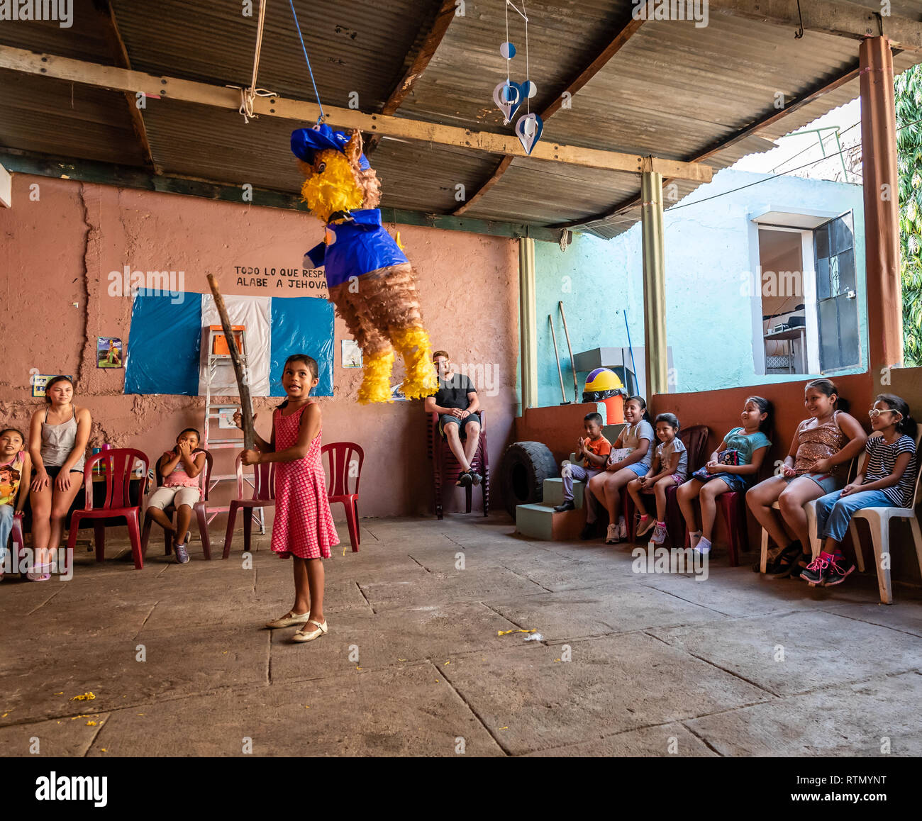 Joven muchacho latino balanceándose en la piñata en la fiesta de